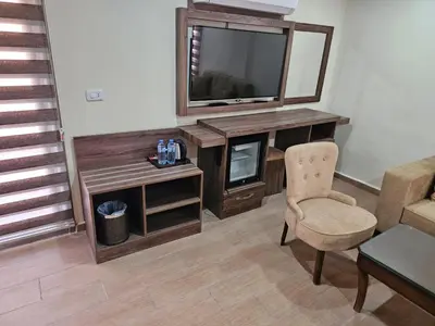a living room with a television and a chair at Sunset Hotel in Wadi Musa
