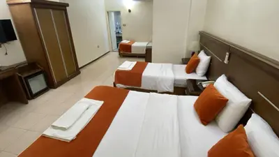a hotel room with two beds with orange pillows at Sunset Hotel in Wadi Musa