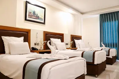 a group of four beds in a hotel room at Al Raad Hotel in Aqaba