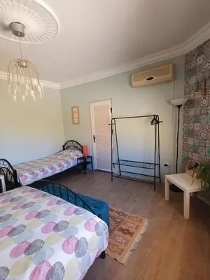 a room with two beds and a chandelier at The Little B&B on the Hill in Wadi Musa