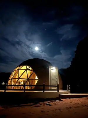 a dome shaped building with a moon in the sky at Beyond Wadi Rum Camp in Wadi Rum