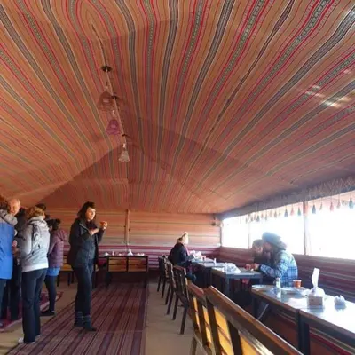 a group of people standing in a restaurant with a ceiling at Wadi Rum Bedouin Way Camp in Wadi Rum