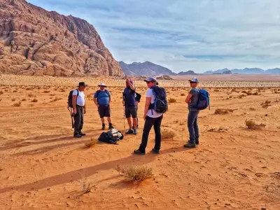 a group of people standing in the desert at Wadi Rum Bedouin Way Camp in Wadi Rum
