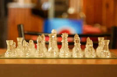 a close up of a glass chess set on a table at The Sydney Hotel in Amman