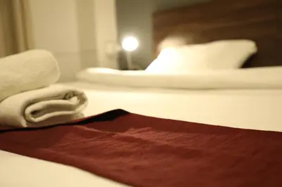 a hotel room with a bed with towels on it at The Sydney Hotel in Amman