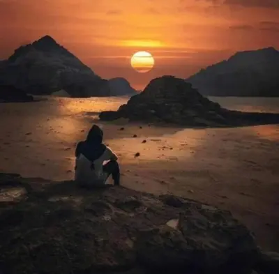 a person sitting on the beach watching the sunset at Yazan Desert Camp in Wadi Rum