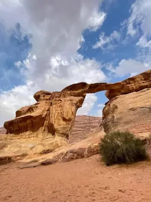 a rock formation in the desert under a cloudy sky at Yazan Desert Camp in Wadi Rum
