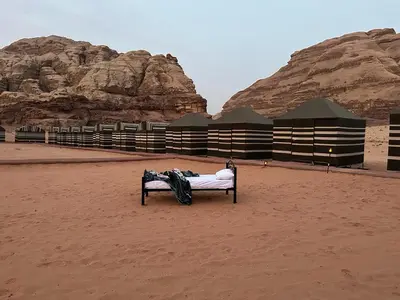 a bench in the middle of a desert with rocks at Bedouin Tours Camp in Wadi Rum