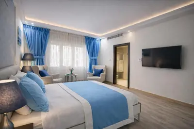 a hotel room with a large bed and a flat screen tv at Al Basem Hotel in Amman