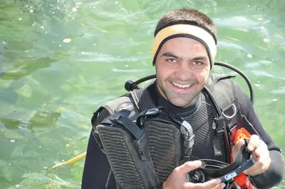 a man in the water holding a camera at Red Sea Dive Center in Aqaba