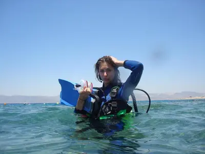 a woman is sitting in the water on a board at Red Sea Dive Center in Aqaba