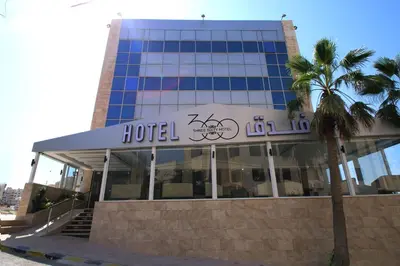 a hotel building with a palm tree in front of it at 360 Hotel By FHM in Amman