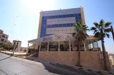 a hotel with palm trees in front of a building at 360 Hotel By FHM in Amman