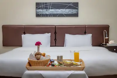 a tray of food on a bed with a tray of food at 360 Hotel By FHM in Amman