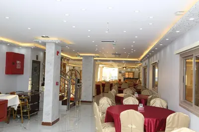 a restaurant with tables and chairs in a room at Venus Hotel in Wadi Musa