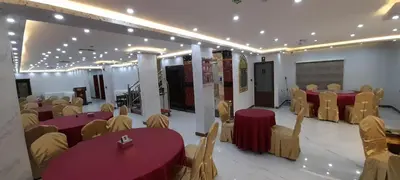 a banquet hall with red tables and yellow chairs at Venus Hotel in Wadi Musa