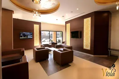 a waiting room with chairs and a table and windows at Viola Hotel Suites in Amman
