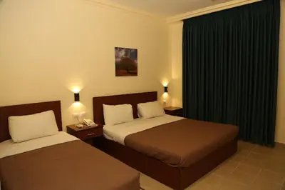 a hotel room with two beds and a window at Rumman Hotel in Madaba