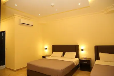 a hotel room with two beds and two lamps at Rumman Hotel in Madaba