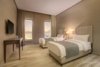 a hotel room with two beds and a television at The House Boutique Suites in Amman
