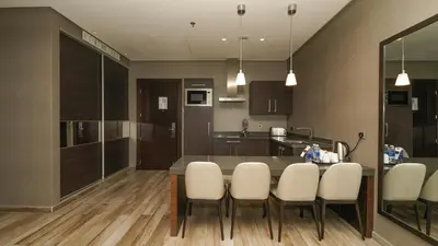 a kitchen with a dining table and white chairs at The House Boutique Suites in Amman