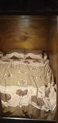 a bed with a white blanket on top of it at Petra cabin Roof top hostel in Wadi Musa