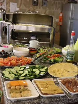 a buffet with many different types of food on a counter at Petra cabin Roof top hostel in Wadi Musa