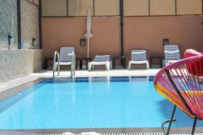 a pool with a bunch of chairs at Almond Hotel Apartments in Amman