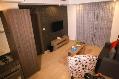 a living room with a couch and a table at Almond Hotel Apartments in Amman