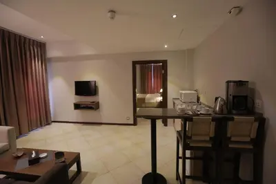 a living room with a table and a tv in a room at Jabal Amman Hotel (Heritage House) in Amman