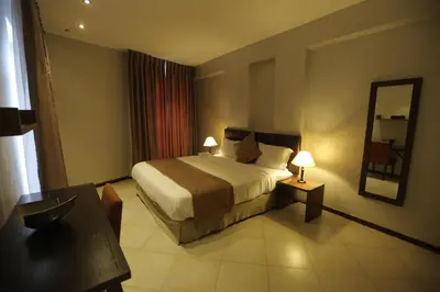 a bedroom with a bed and a table and a mirror at Jabal Amman Hotel (Heritage House) in Amman