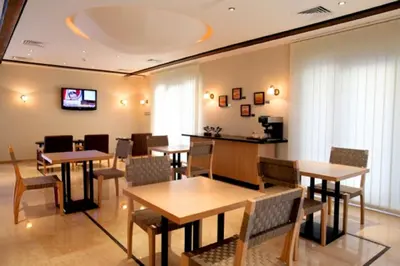 a dining room with tables and chairs and a tv at Jabal Amman Hotel (Heritage House) in Amman