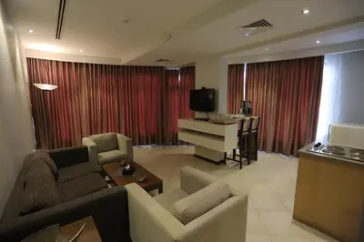 a living room with a couch and chairs and a television at Jabal Amman Hotel (Heritage House) in Amman