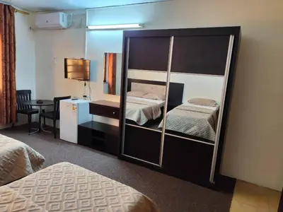 a hotel room with two beds and a mirror at Asia Hotel in Amman