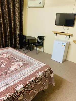 a room with a bed and a table and a tv at Asia Hotel in Amman