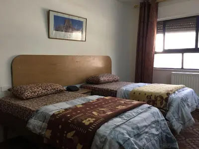 a bedroom with two beds and a window at Asia Hotel in Amman