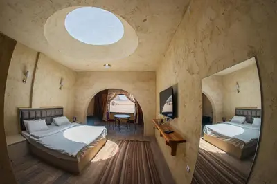 a large room with two beds and a window at Bait Ali in Wadi Rum