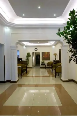 a hallway with chairs and a piano in a building at Barakat Hotel Apartments in Amman