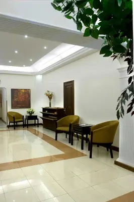 a waiting room with a piano and chairs at Barakat Hotel Apartments in Amman