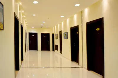a hallway with black doors and a white tile floor at Public Security Hotel & Chalets in Aqaba