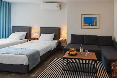 a hotel room with two beds and a couch at Canary Boutique Hotel in Amman