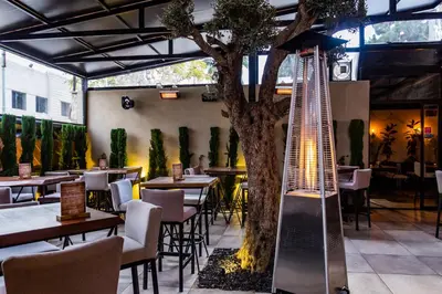 a restaurant with a tree and tables and chairs at Canary Boutique Hotel in Amman