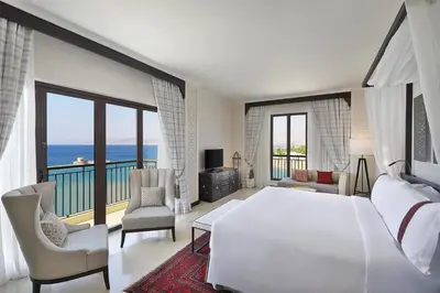 a bedroom with a large white bed and a balcony at Al Manara, a Luxury Collection Hotel, Aqaba in Aqaba