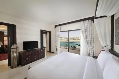 a bedroom with a bed and a tv and a window at Al Manara, a Luxury Collection Hotel, Aqaba in Aqaba