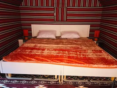 a bedroom with a large bed with two pillows at Desert Rock camp in Wadi Rum