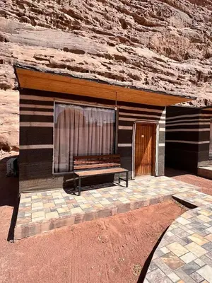 a bench sitting in front of a building at Hasan Zawaideh Camp in Wadi Rum