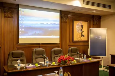 a boardroom with a large screen in a conference room at Amman International Hotel in Amman