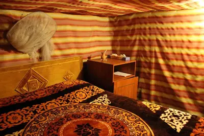 a bedroom with a bed and a dresser in a room at Seven Wonders Bedouin Camp in Wadi Musa