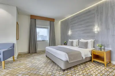 a hotel room with a large bed and a window at Geneva Hotel in Amman