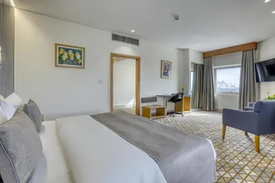 a hotel room with a bed and a desk at Geneva Hotel in Amman